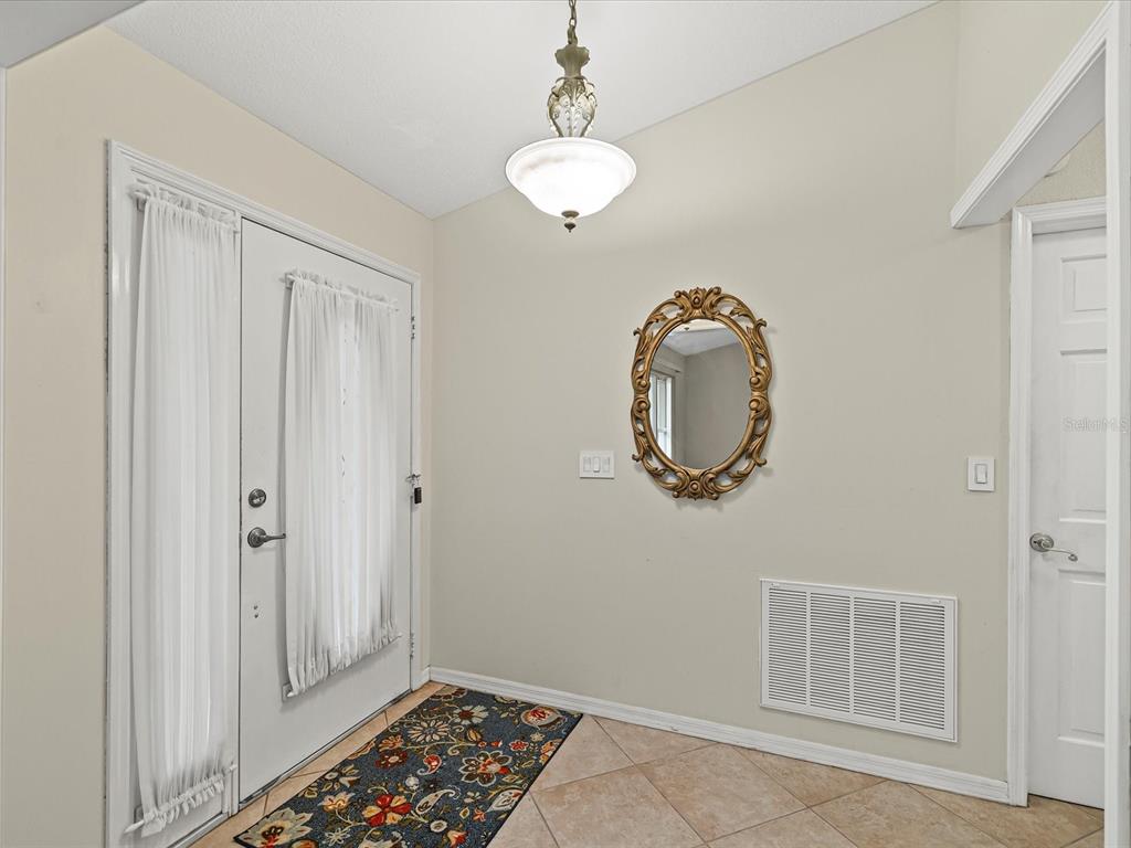 12595 93rd Way North Largo, FL 33773 - Photo 12 of 53 a room with wooden floor and glass door
