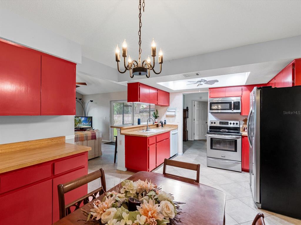 12595 93rd Way North Largo, FL 33773 - Photo 18 of 53 a kitchen with stainless steel appliances kitchen island granite countertop a refrigerator stove top oven and sink
