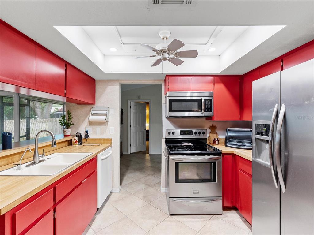 12595 93rd Way North Largo, FL 33773 - Photo 19 of 53 a kitchen with stainless steel appliances kitchen island granite countertop a sink stove and refrigerator