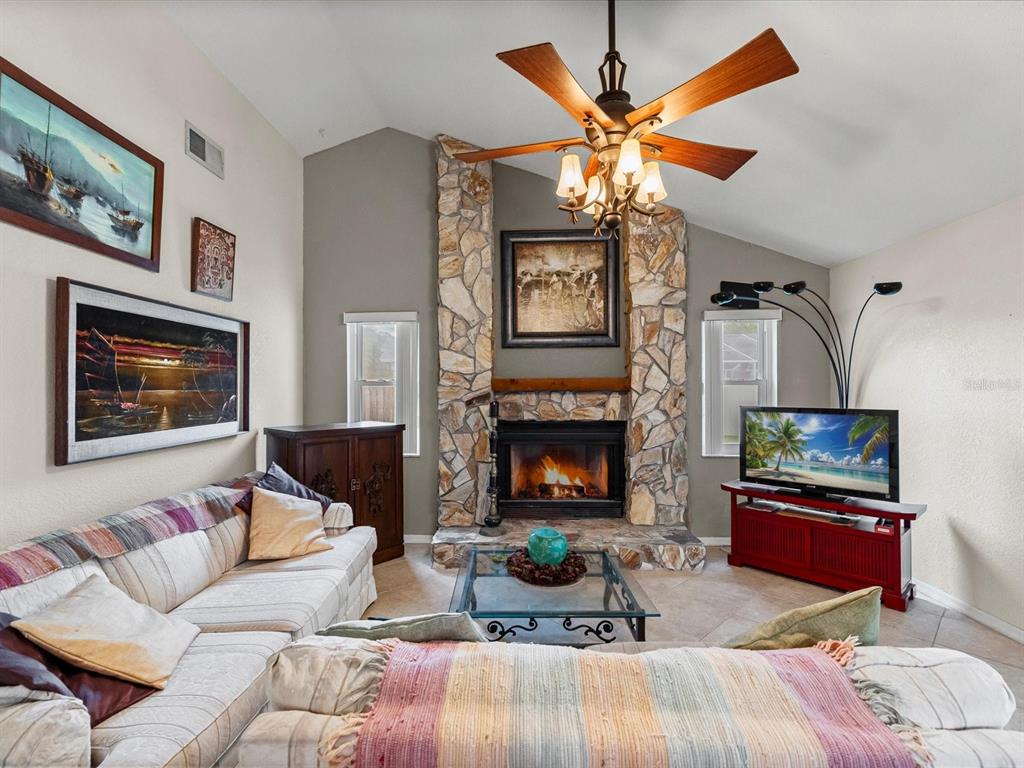 12595 93rd Way North Largo, FL 33773 - Photo 2 of 53 a living room with furniture a flat screen tv and a fireplace