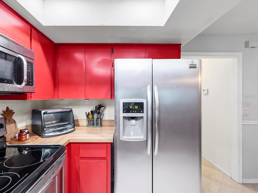 12595 93rd Way North Largo, FL 33773 - Photo 23 of 53 a kitchen with stainless steel appliances granite countertop a refrigerator and a stove