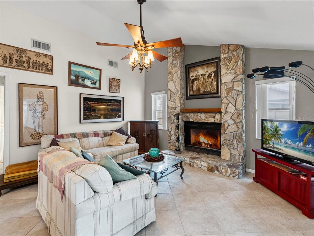 12595 93rd Way North Largo, FL 33773 - Photo 25 of 53 a living room with furniture a flat screen tv and a fireplace