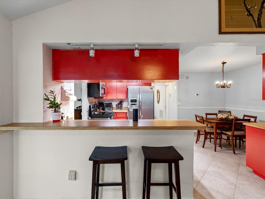 12595 93rd Way North Largo, FL 33773 - Photo 26 of 53 a dining room with stainless steel appliances kitchen island granite countertop a dining table and chairs