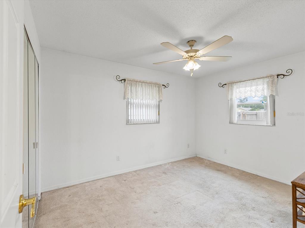 12595 93rd Way North Largo, FL 33773 - Photo 30 of 53 an empty room with windows and fan