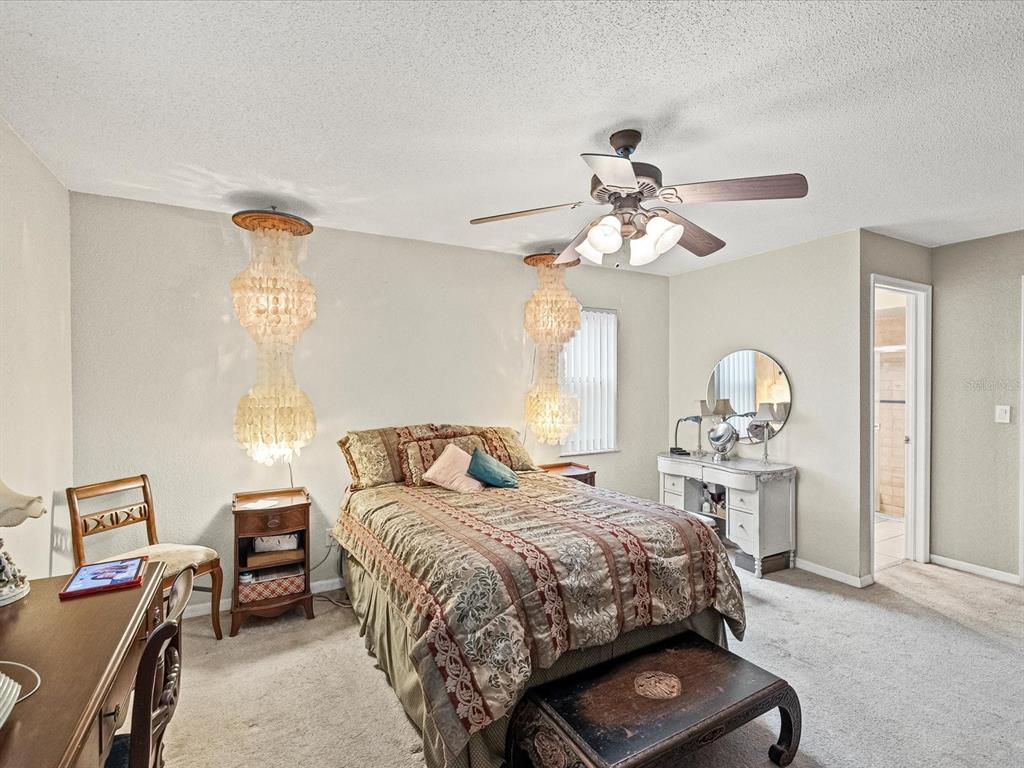 12595 93rd Way North Largo, FL 33773 - Photo 9 of 53 a bedroom with a bed and a chandelier