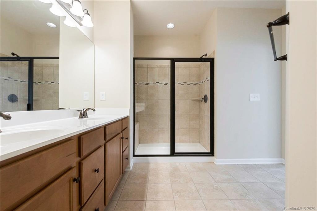 130 Inlet Point Drive Tega Cay, SC 29708 - Photo 5 of 13 a bathroom with a double vanity sink a shower and a mirror