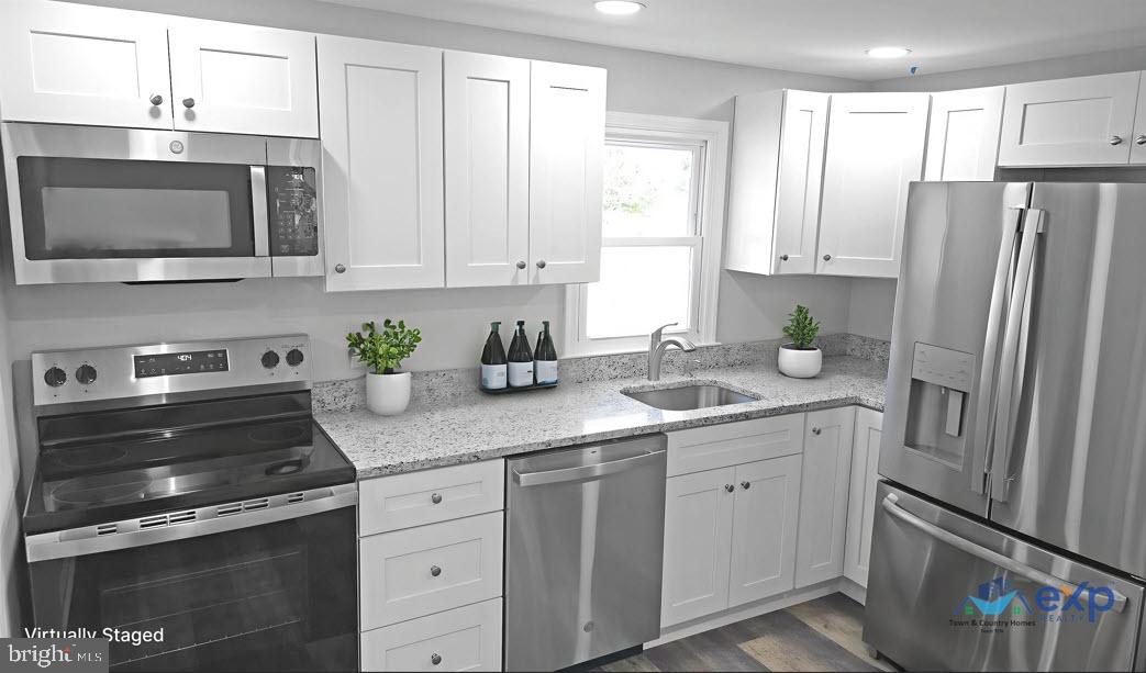 233 Main Street Hartly, DE 19953 - Photo 3 of 26 a kitchen with stainless steel appliances white cabinets and a stove top oven