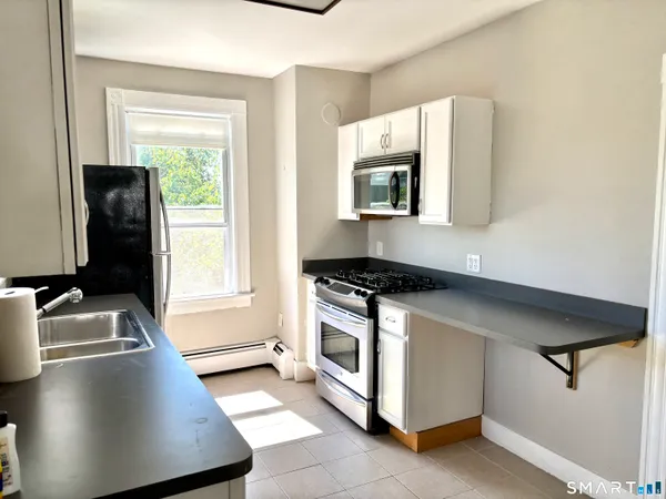 a kitchen with stainless steel appliances granite countertop a sink stove and microwave