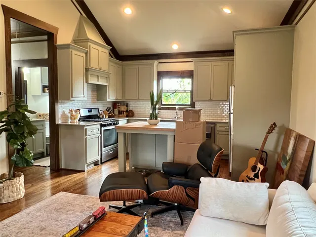 a kitchen with a granite countertop sink stove and cabinets