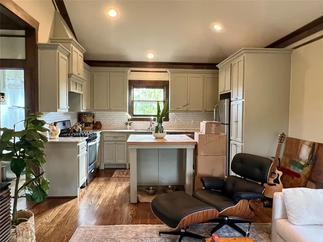 a living room with furniture a large window and a wooden floor
