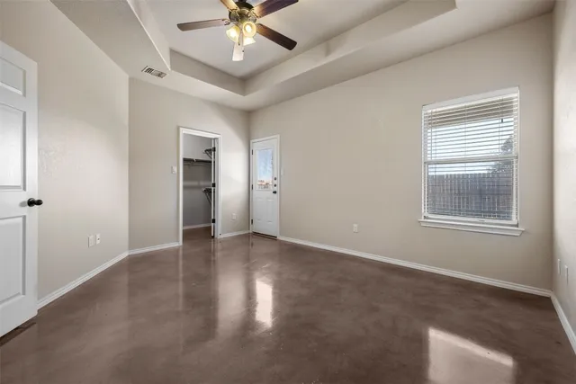 an empty room with a window and a fan
