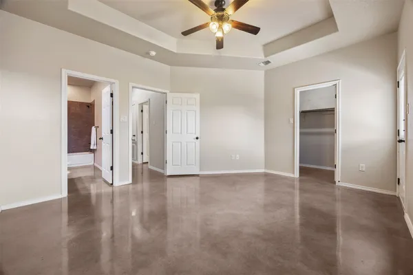 an empty room with fan and windows