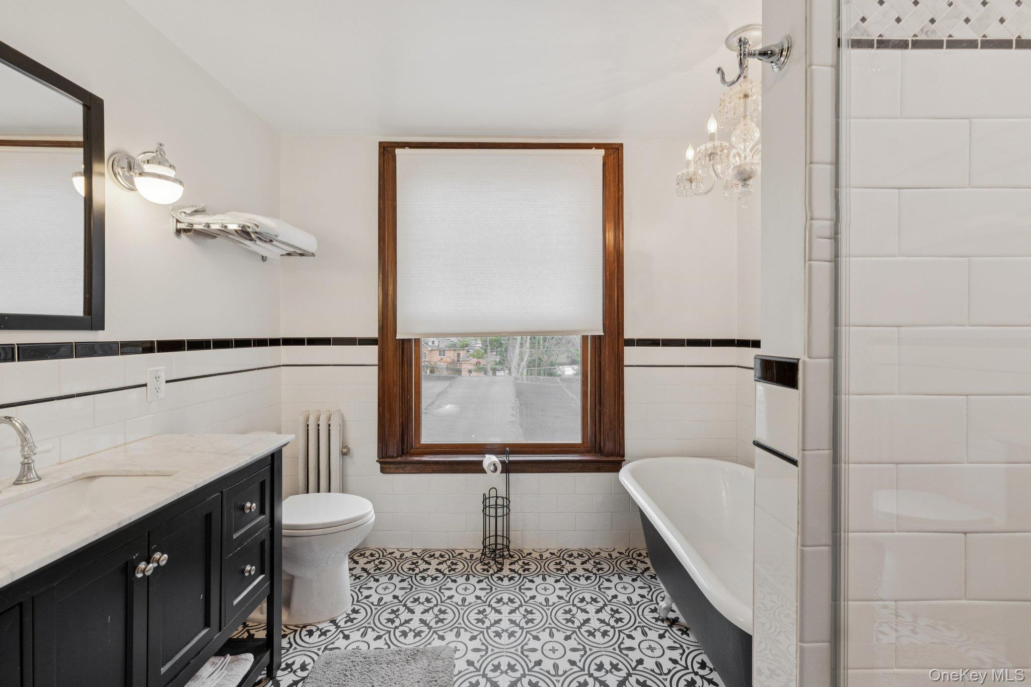 397 Split Rock Road Syosset, NY 11791 - Photo 16 of 29 a bathroom with a tub a sink and a window