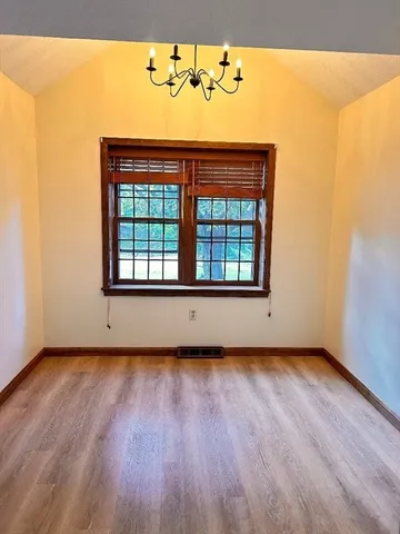 an empty room with wooden floor and a window