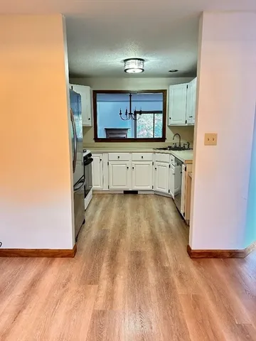a large kitchen with a lot of counter space and wooden floor