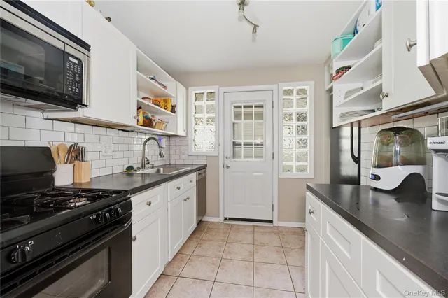 a kitchen with stainless steel appliances granite countertop a sink and a stove