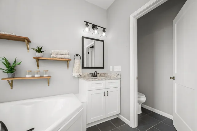 a bathroom with a toilet sink and mirror