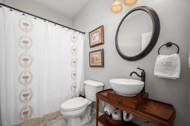 a bathroom with a toilet a sink and a mirror