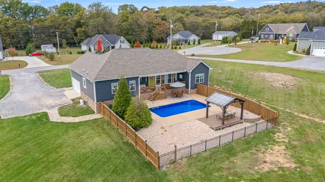 an aerial view of a house with swimming pool garden and patio