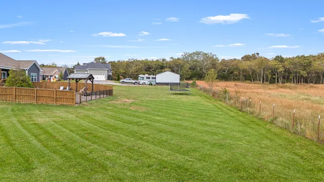 a front view of a house with a yard and lake view