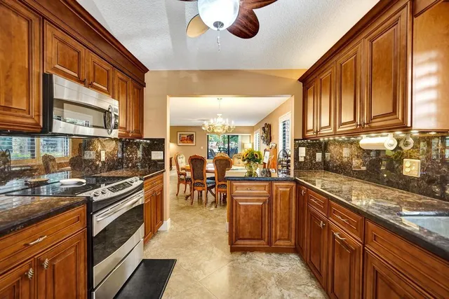 a bathroom with a granite countertop sink toilet a mirror and shower