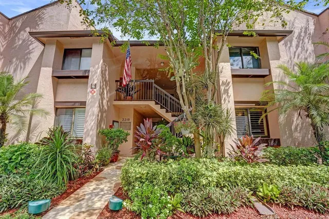 a view of a house with a yard and flower plants