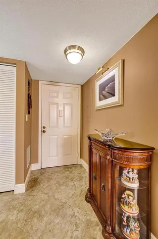 a dining room with furniture a chandelier a large window and a kitchen view