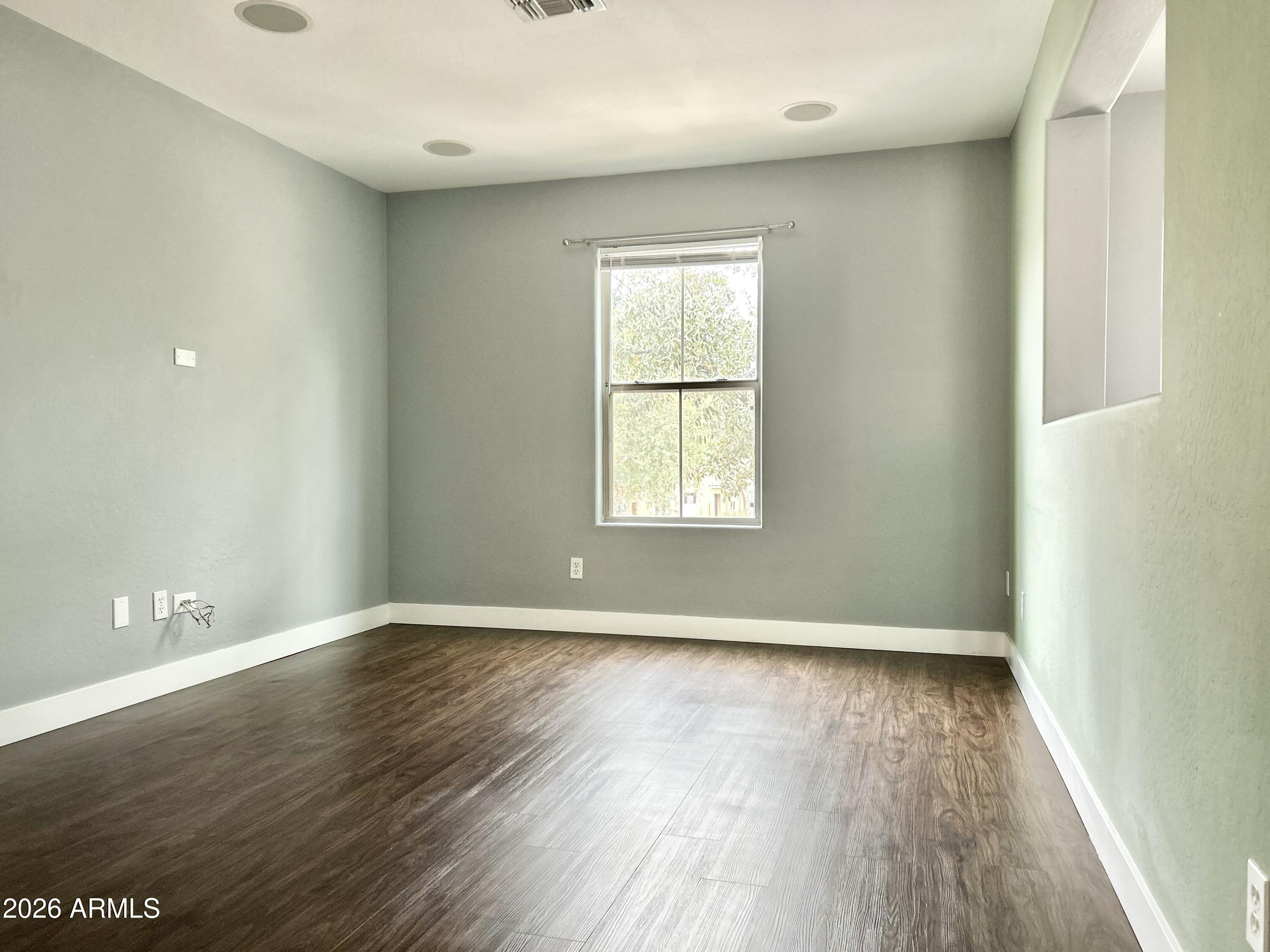 451 South Hawes Road, Unit 43 Mesa, AZ 85208 - Photo 13 of 23 an empty room with wooden floor and windows