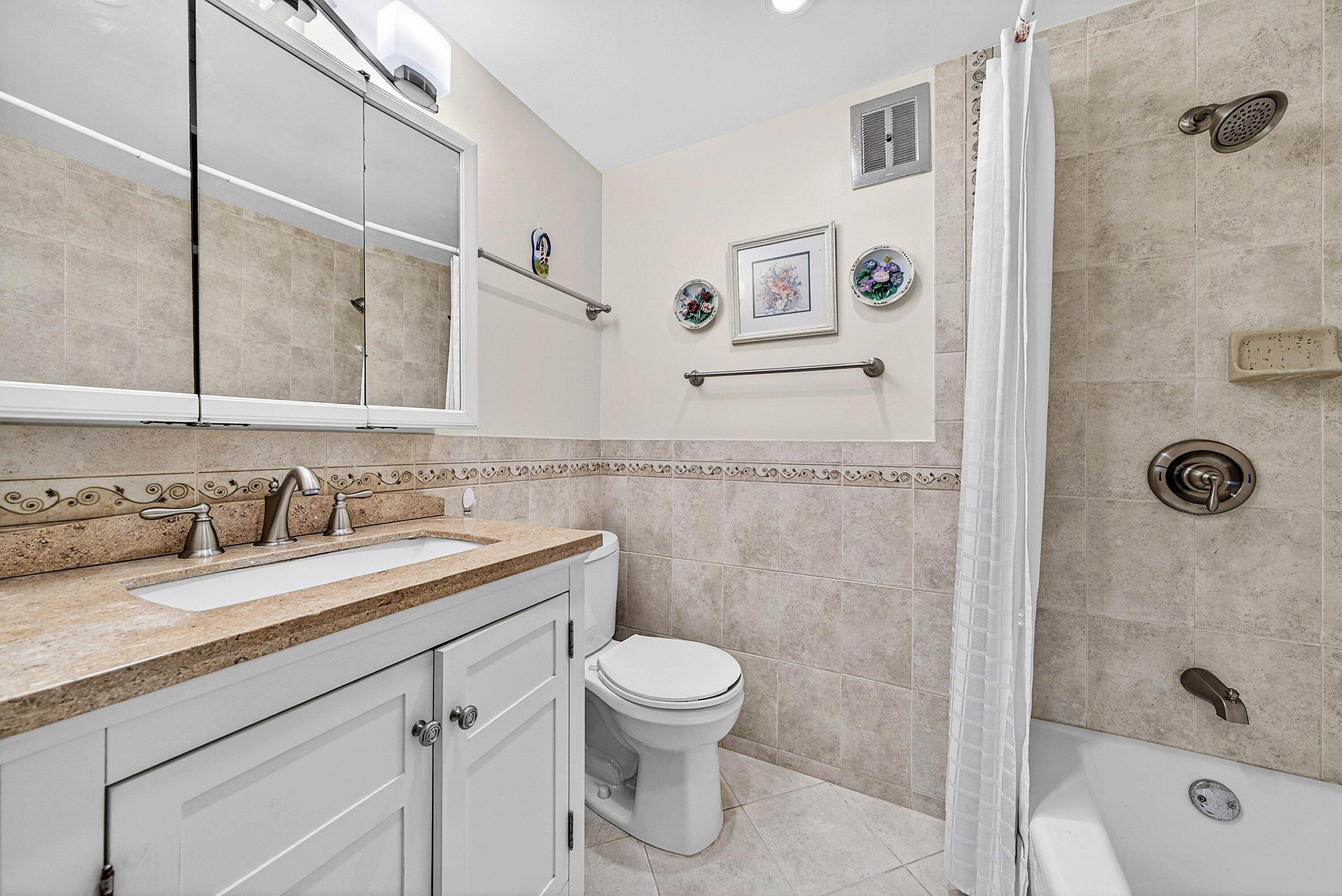 300 Northeast 20th Street, Unit 308 Boca Raton, FL 33431 - Photo 18 of 40 a bathroom with a granite countertop sink a toilet and shower