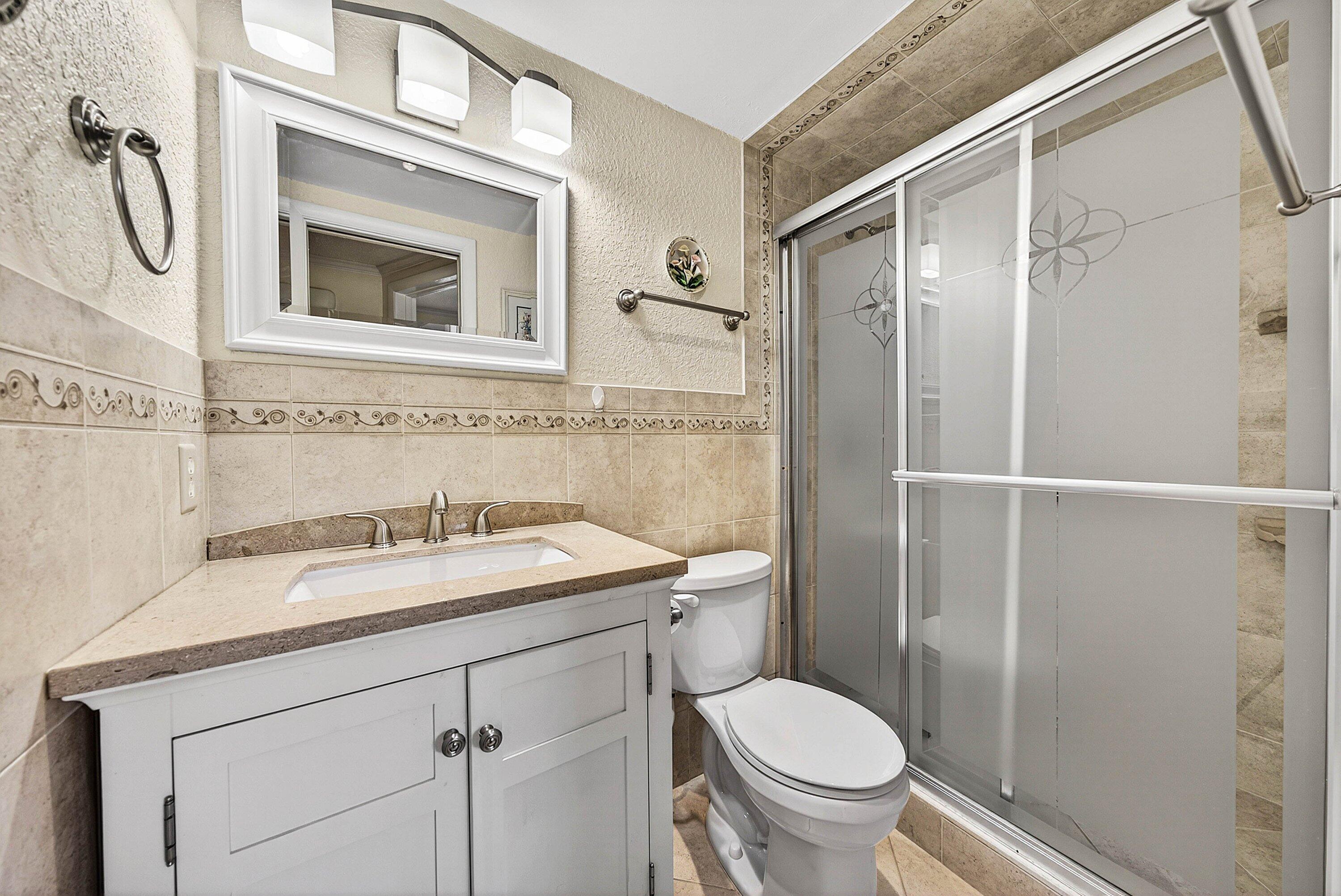 300 Northeast 20th Street, Unit 308 Boca Raton, FL 33431 - Photo 22 of 40 a bathroom with a granite countertop sink toilet and shower