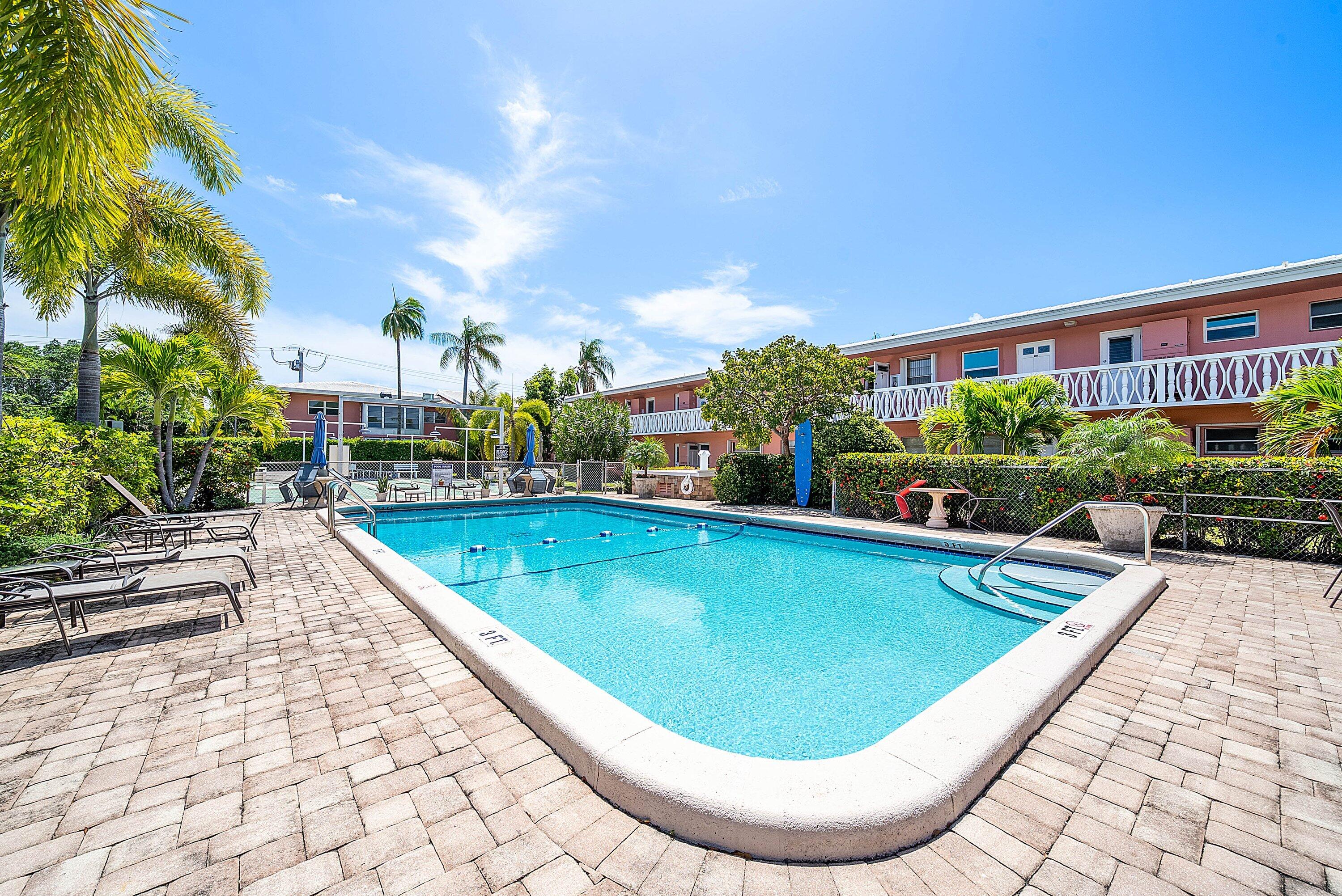 300 Northeast 20th Street, Unit 308 Boca Raton, FL 33431 - Photo 29 of 40 a view of swimming pool that has lawn chairs plants and palm trees