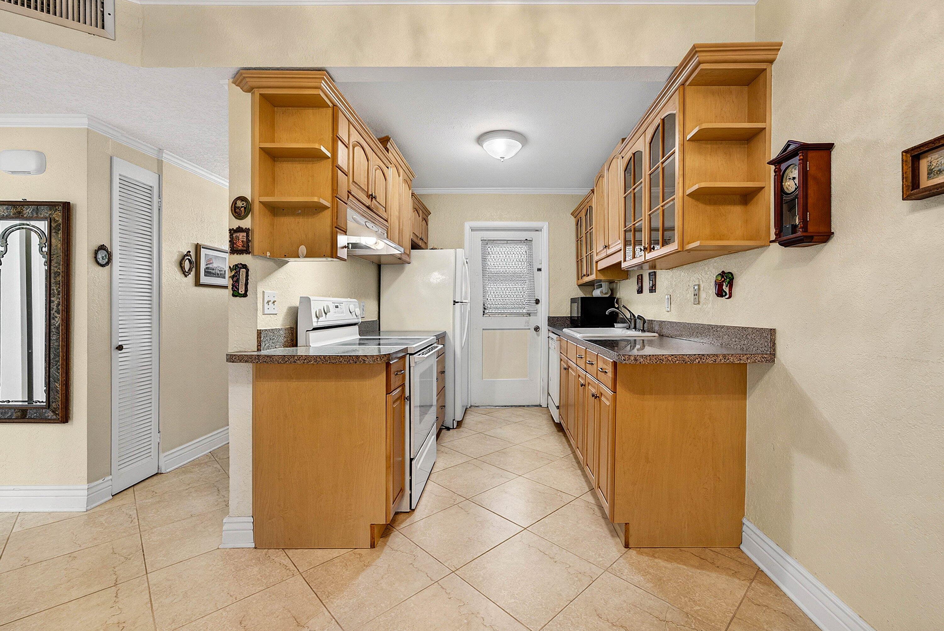 300 Northeast 20th Street, Unit 308 Boca Raton, FL 33431 - Photo 6 of 40 a kitchen with stainless steel appliances granite countertop a refrigerator and a stove