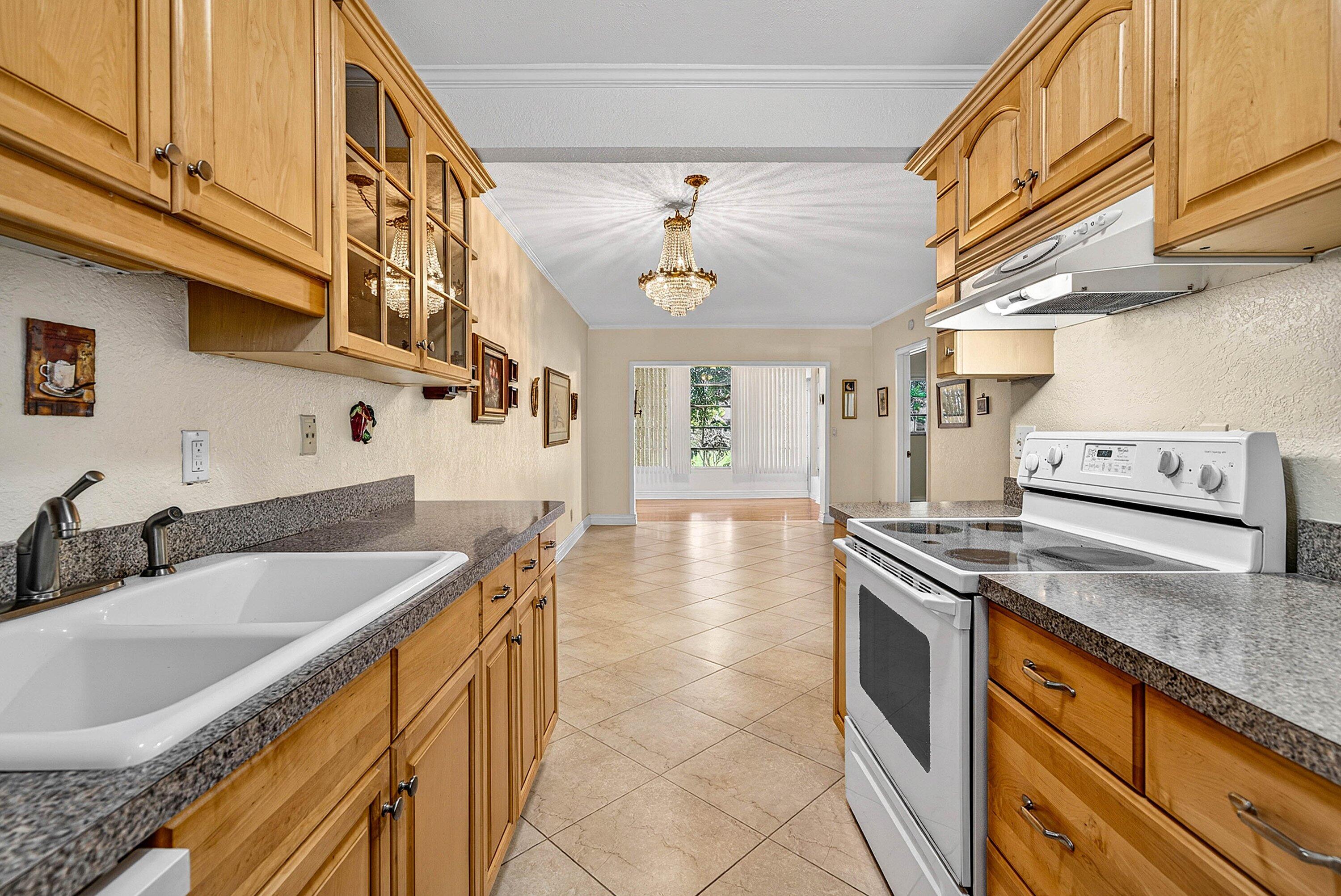 300 Northeast 20th Street, Unit 308 Boca Raton, FL 33431 - Photo 8 of 40 a kitchen with stainless steel appliances granite countertop a sink a stove and cabinets