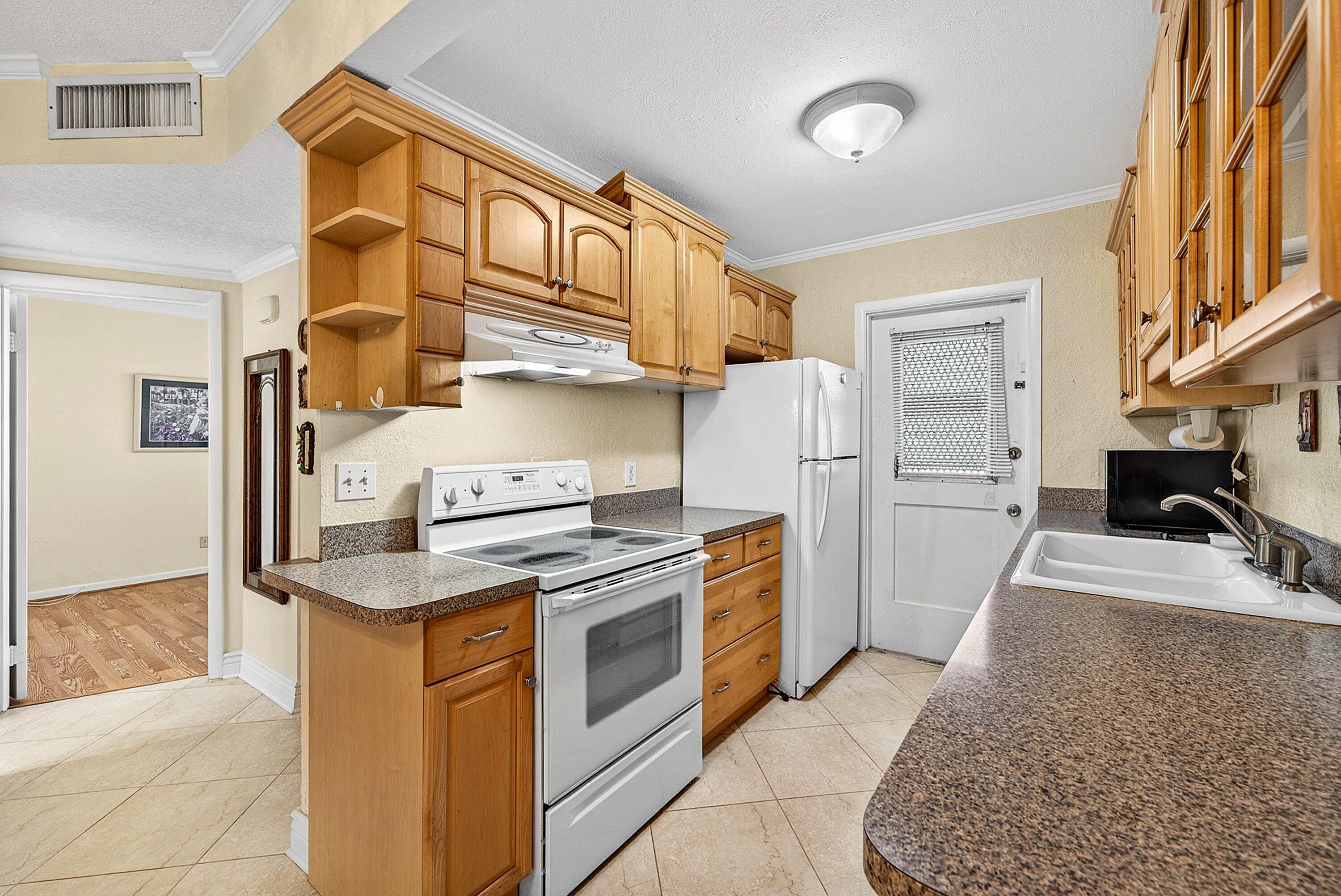 300 Northeast 20th Street, Unit 308 Boca Raton, FL 33431 - Photo 9 of 40 a kitchen with stainless steel appliances granite countertop a refrigerator a stove and a sink with cabinets
