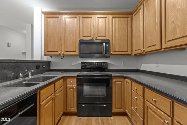 a kitchen with granite countertop a sink a stove and cabinets