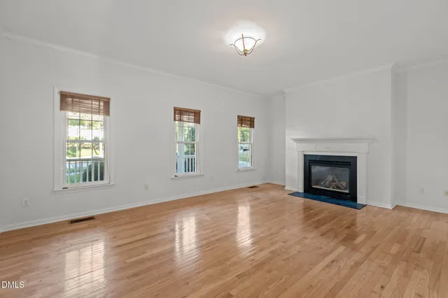 a view of an empty room with a window and fireplace