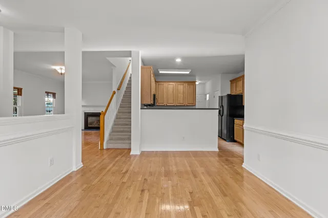 a view of a hallway with wooden floor and staircase