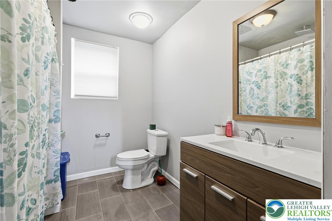 732 Bushkill Center Road Nazareth, PA 18064 - Photo 29 of 43 A well-appointed bathroom features a modern vanity and ample natural light through a privacy-blinded window.