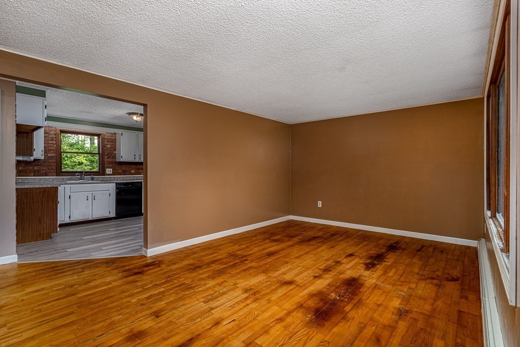 123 Dunn Road Ashburnham, MA 01430 - Photo 4 of 42 an empty room with wooden floor and windows