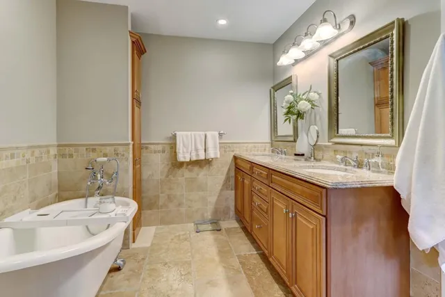 a bathroom with a tub sink and mirror