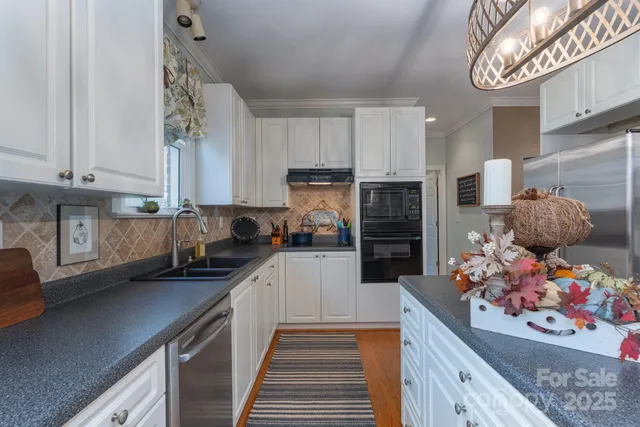a kitchen with stainless steel appliances granite countertop a stove refrigerator sink and cabinets