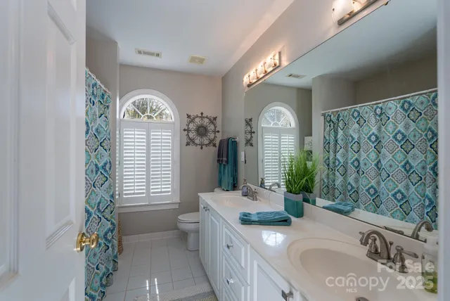 a bathroom with a granite countertop sink a large mirror and a shower