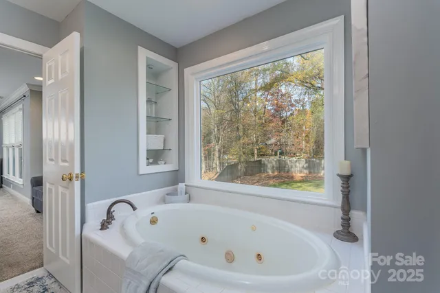 a white bath tub sitting in a bathroom next to a window