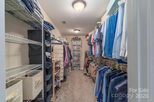a view of walk in closet with clothes
