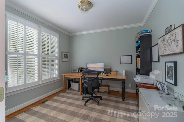 a view of a workspace with furniture and a window