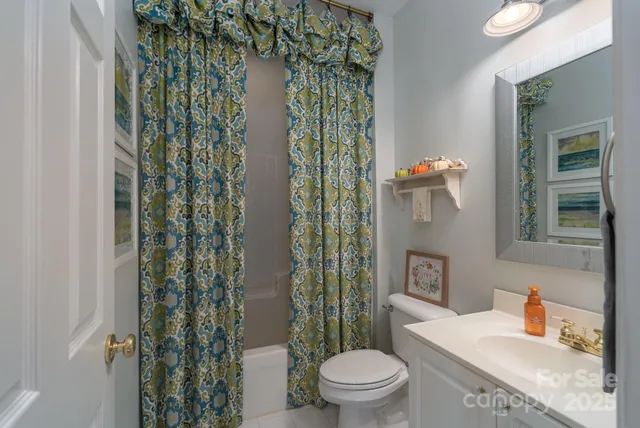 a bathroom with a granite countertop toilet a sink and a shower