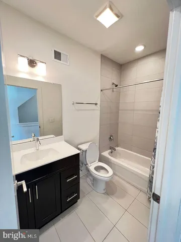 a bathroom with a double vanity sink mirror and toilet