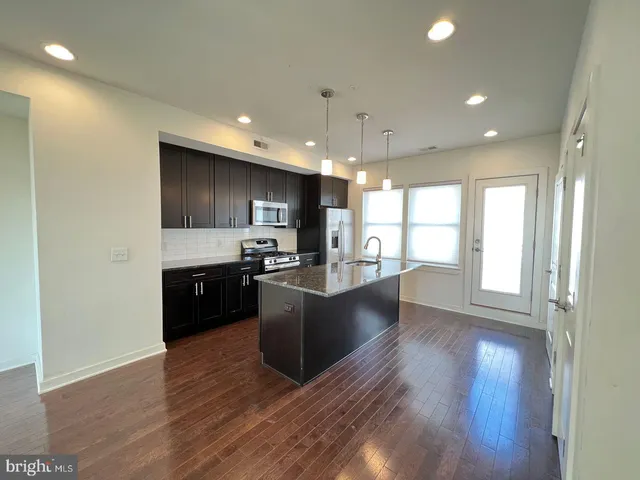 a kitchen with stainless steel appliances kitchen island wooden cabinets and granite counter tops