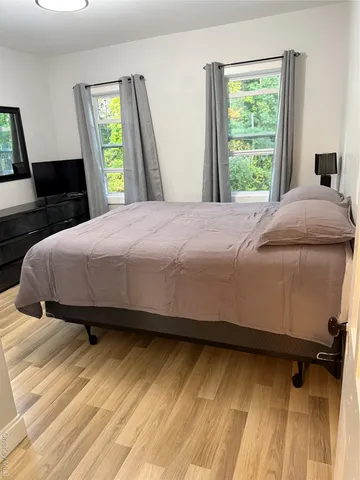 a bedroom with a bed and wooden floor