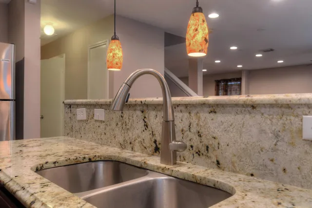 a close view of a sink a faucet a projector and screen in a bathroom